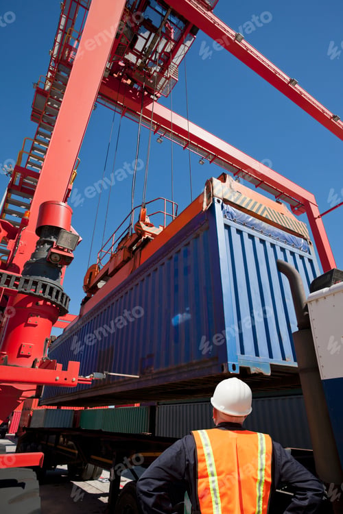 Preview: A Worker Observing The Cargo Container Being Place On The Lorry