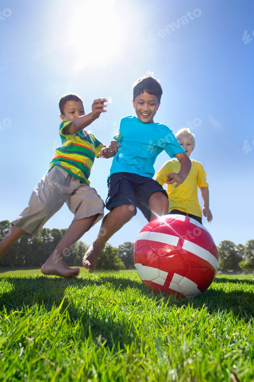 Preview: Vertical Shot Of Smiling Boys Playing Soccer In A Park