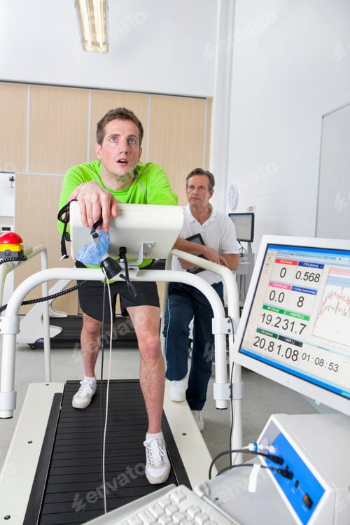 Preview: Wide Shot Of A Sports Scientist Monitoring An Exhausted Runner Holding Mask On A Treadmill In A