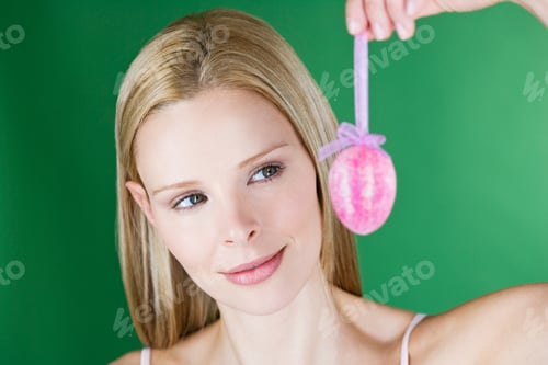 Preview: A Portrait Of A Young Blonde Woman Holding A Pink Easter Egg