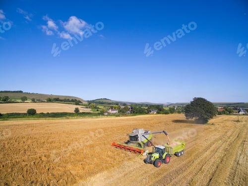 Preview: Combine Harvester Filling Tractor Trailer In A Sunny Rural Barley Field
