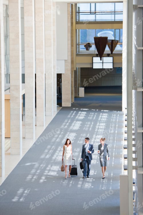 Preview: Vertical Shot Of Business Employees Walking In The Lobby Of A Modern Office