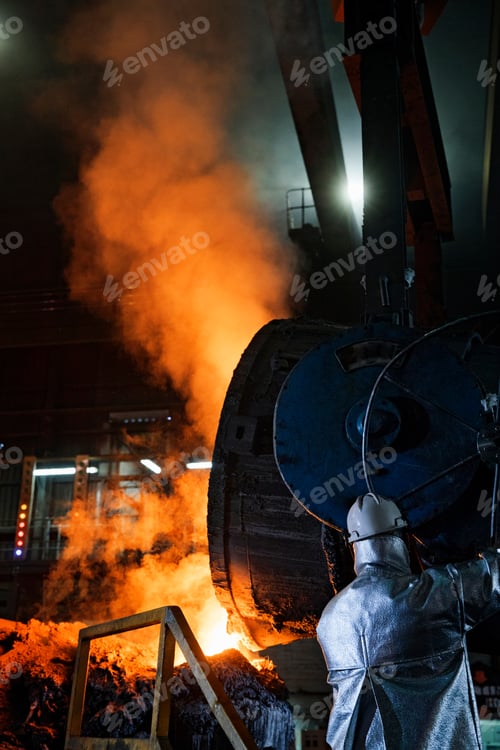 Preview: Worker In Protective Clothing Pouring Molten Metal In Foundry
