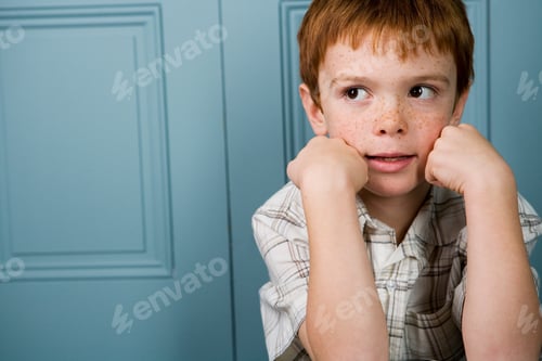 Preview: Boy With Ginger Hair Resting Face In Hands