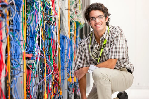 Preview: Young Technician Kneeling Next To A Cabinet In The Server Room Of A Data Center And Smiling At The