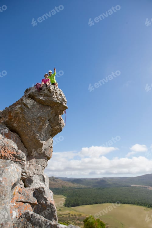 Preview: Extreme Wide Shot Of Rock Climbers Sitting On The Top Of A Rock And Enjoying The View.