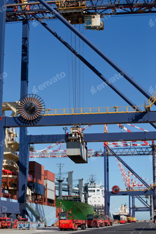 Preview: Vertical Shot Of A Crane Unloading Cargo Containers From A Ship Moored At A Commercial Dock.