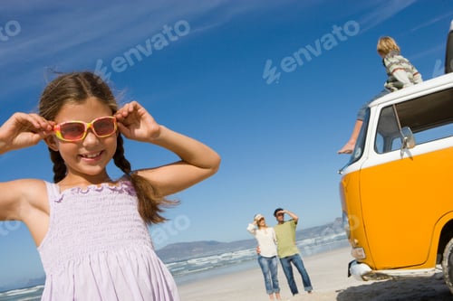 Preview: Girl At Camera In Sunglasses By Camper Van On Family Beach Vacation