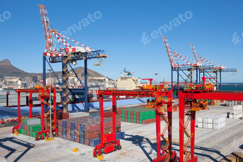 Preview: High-Angle Shot Of Cranes And Cargo Containers At A Commercial Dock With Mountains In Background.