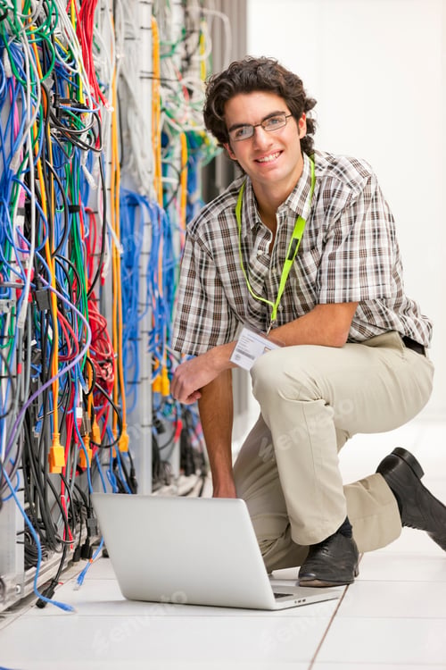 Preview: Vertical Shot Of A Technician Kneeling Next To A Cabinet In The Server Room Of A Data Center And