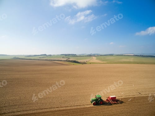 Visualização: Vista aérea do trator puxando uma broca semeando sementes no campo