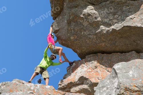 Preview: Low-Angle Shot Of An Instructor Helping A Female Rock Climber.