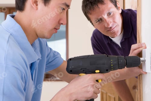 Preview: Electrician With Apprentice Drilling Outlet In Wall Of New House