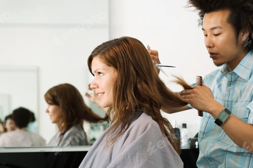 Preview: Young Male Hairdresser Cutting Woman'S Hair In Salon With Profile Reflection In Mirror.
