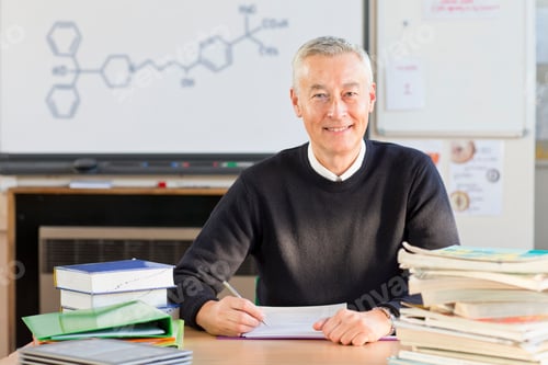 Preview: Portrait Confident Science Teacher Grading Homework In Classroom