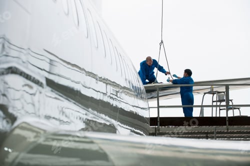 Preview: Wide Shot Of Engineers Assembling The Tail Wing Of A Passenger Jet At A Hangar.