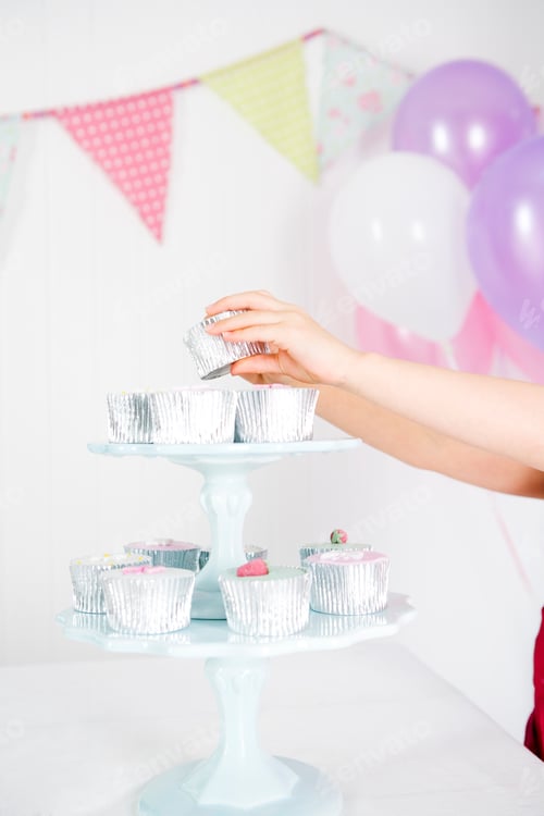 Preview: Girl'S Hand Taking Cake From Cake Stand At Birthday Party