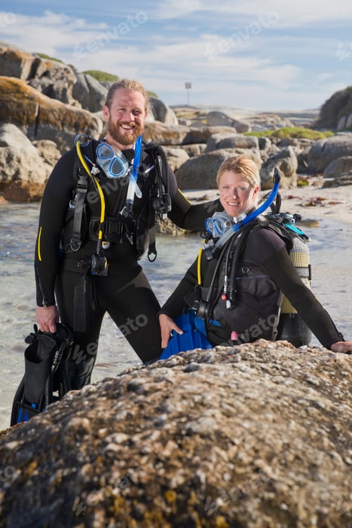Preview: Couple In Wetsuits Going Ocean Scuba Diving From Rocky Beach And Smiling At Camera