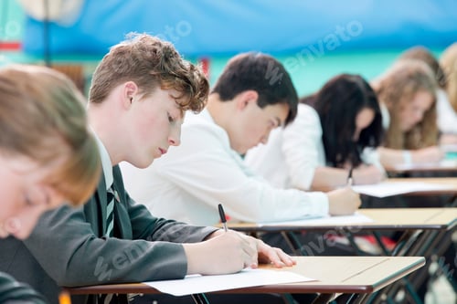 Preview: Focused Middle School Students Taking Examination At Desks