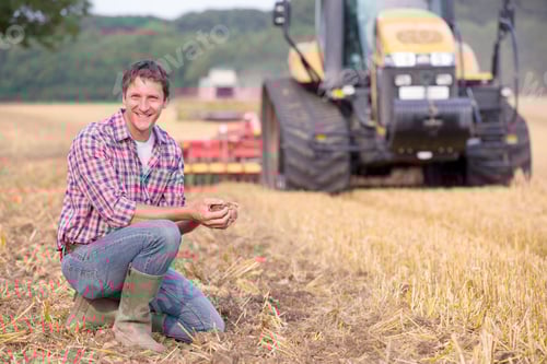 Preview: Farmer Examining Soil In Field As It Is Harrowed