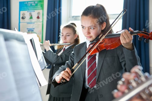 Preview: High School Student Reading Sheet Music And Playing A Violin In A Music Class.