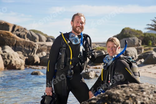 Preview: Couple In Wetsuits Going Ocean Scuba Diving From Rocky Beach And Smiling At Camera