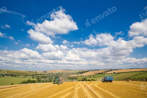 Preview: Wide Shot Of Multiple Tractors Bailing Straw In A Rural Field.