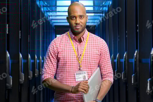 Preview: Portrait Of It Technician In Data Centre Standing By Servers