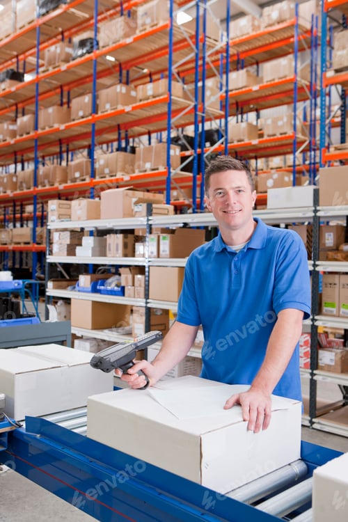 Preview: Vertical Shot Of A Worker Smiling At The Camera While Scanning Paperwork And A Box At The