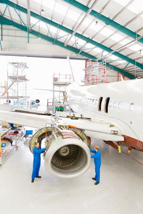Preview: Extreme Wide Shot Of Engineers Assembling An Engine On A Passenger Jet At A Hangar.
