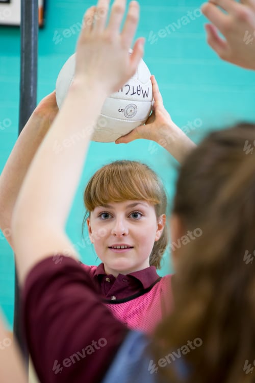 Preview: Vertical Shot Of A High School Student Throwing A Netball During A Gym Class.