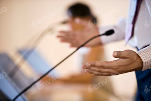 Preview: Selective Focus On Businessman'S Hand As He Gives Presentation With Businesswoman In Back.