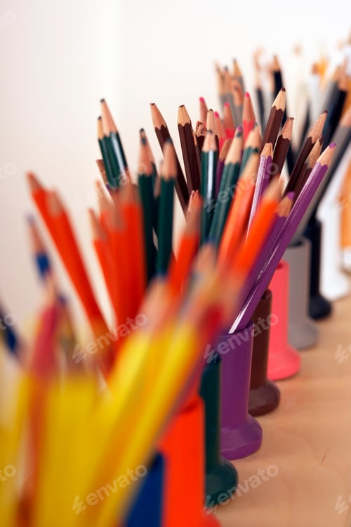Preview: Vertical Close-Up Shot Of A Row Of Multi-Colored Coloring Pencils In Pots With Selective Focus.