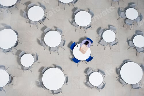 Preview: Businessman Working On Laptop At Table Of Office Canteen