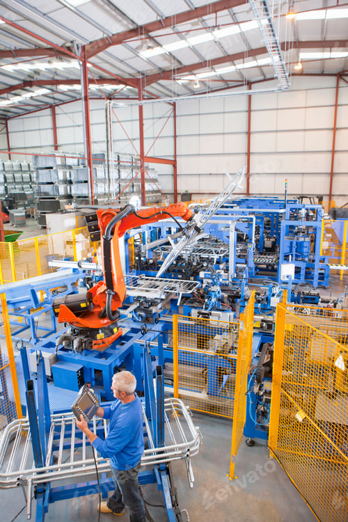 Preview: Worker Controlling Robotic Machinery Lifting Steel Fencing In Manufacturing Plant