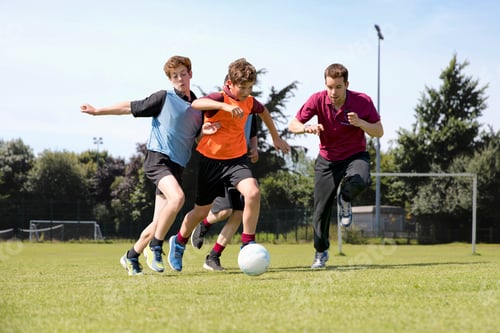 Preview: Wide Shot Of Middle Schoolboys And Teacher Running While Playing Soccer On The Field In Physical