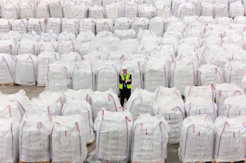 Preview: Portrait Of Businessman Standing Among Large Bags Of Recycled Plastic Pellets In Warehouse
