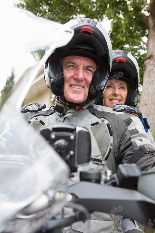Preview: Vertical Shot Of An Elderly Couple Wearing Motorcycle Helmets And Sitting On A Motorcycle.