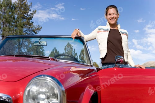 Preview: Smiling Mature Woman Next To Classic Convertible Car At Camera