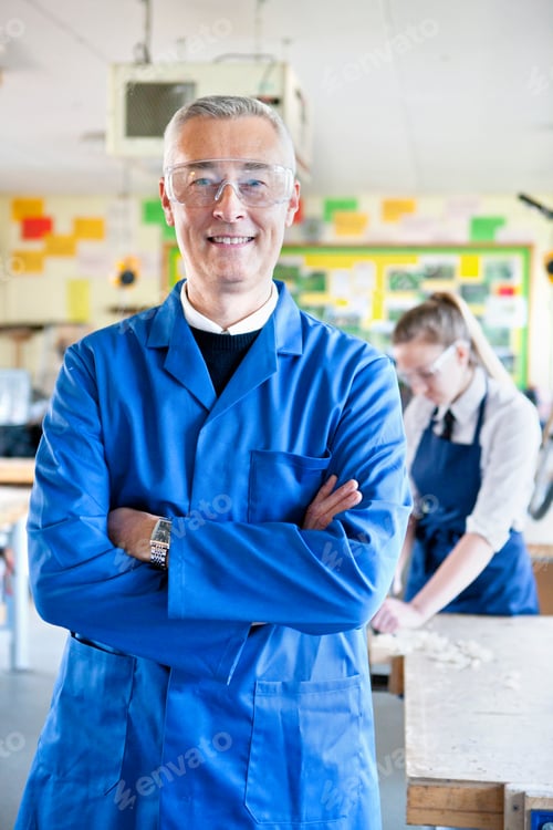 Visualização: Retrato vertical de um professor em pé em uma oficina de aula de oficina.