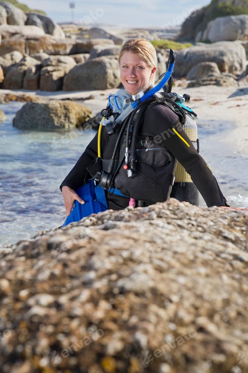 Preview: Woman In Wetsuit Going Ocean Scuba Diving From Rocky Beach And Smiling At Camera