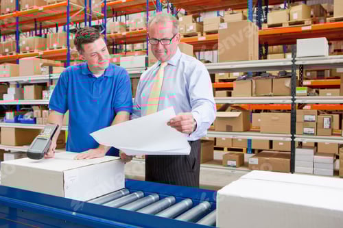 Preview: Medium Shot Of A Worker And Supervisor Examining Paperwork And Scanning A Box At The Production