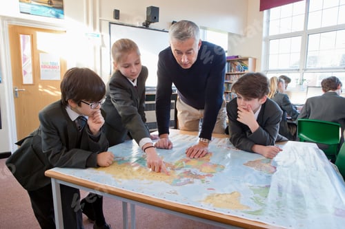 Preview: Geography Teacher And Middle School Students Using A Map In The Classroom.