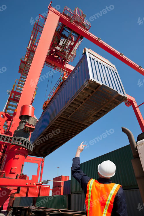 Preview: A Worker Directing The Crane Controller While Placing Cargo Container On A Lorry