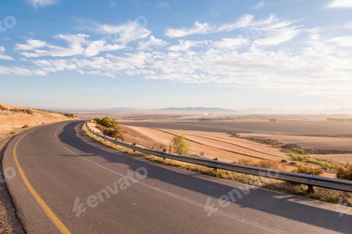 Preview: View Of Long Open Road At Sunrise In Arid Landscape