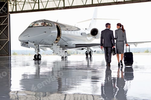 Preview: Businesswoman And Businessman Walking Towards A Private Jet
