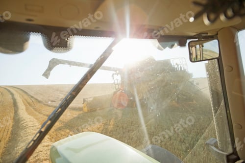 Preview: Combine Harvester Viewed From Cab Of Tractor In Sunny Rural Field