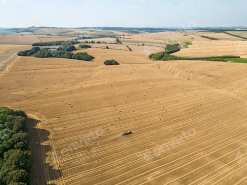 Preview: Aerial Landscape Of Tractor Baler Straw Bales In Farm Fields After Wheat Harvest In Summer