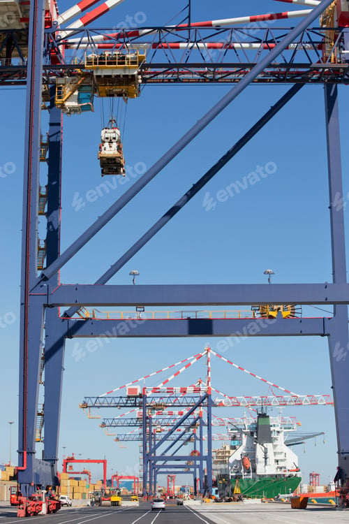 Preview: Vertical Shot Of A Dockyard With A Row Of Gantry Cranes And A Ship