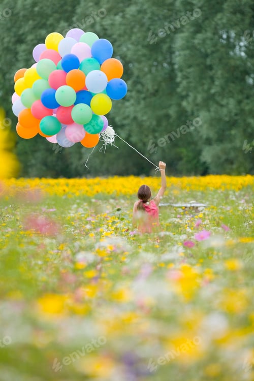 Preview: Vertical Wide Shot Of The Backside Of A Girl Holding A Bunch Of Balloons And Standing Among